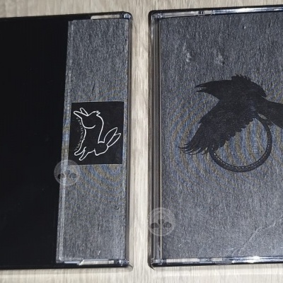 Duas capas de cassetes com desenhos de coelho e corvo em textura cinzenta e preta