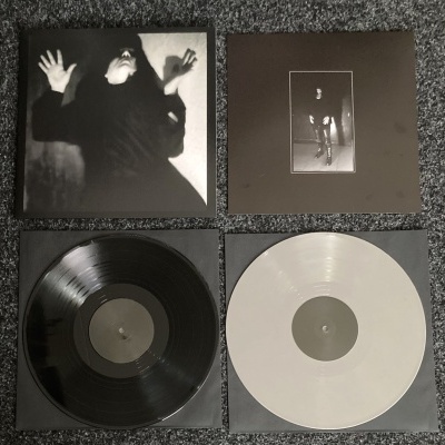 Dois discos de vinil, um preto e um branco, com duas capas fotográficas a preto e branco.