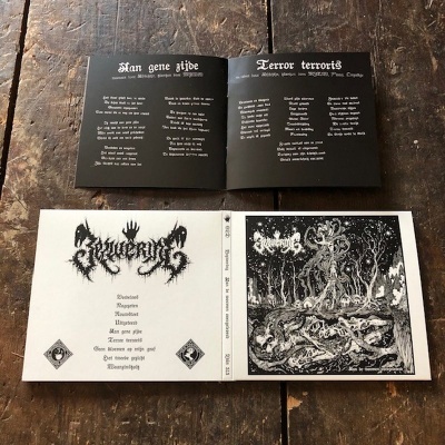 Álbum de música com arte preta e branca, letras góticas e imagens de criaturas fantásticas numa mesa de madeira.