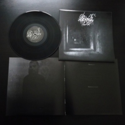 Disco de vinil preto com capa e encarte escuros com textos e imagens ténues