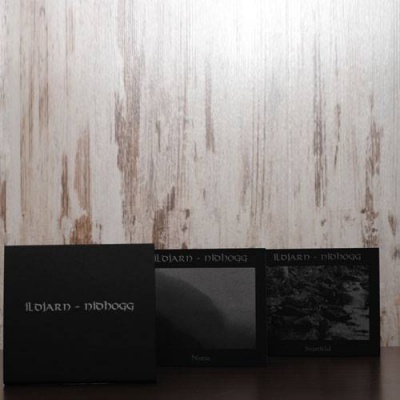 Caixas pretas com texto ILDJARN - NIHLOGG sobre superfície escura e parede de madeira clara