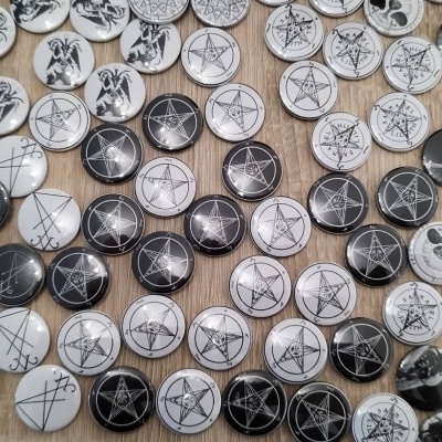 Bolas de metal decorativas com desenhos em preto e branco sobre madeira clara