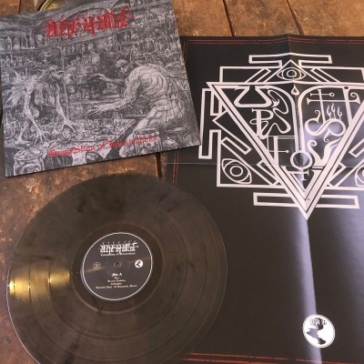 Disco vinil preto, capa de álbum detalhada com texto vermelho e poster preto com símbolo geométrico branco em piso de madeira.