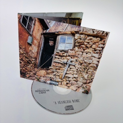 CD e capa com fotografia de casa velha de pedra e homem vestido de preto