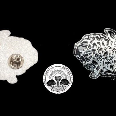 Dois alfinetes metálicos com formatos irregulares e diferentes texturas, um branco com dois fixadores e outro preto com texto prateado.