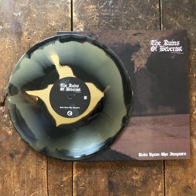 Disco de vinil preto, bege e cinzento ao lado da capa escura com texto 'The Ruins Of Beverast' e 'Sein Upon The Impure'.