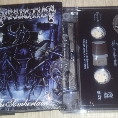 Cassete de áudio preta e caixa transparente com capa de álbum ilustrada e texto da banda Dissection