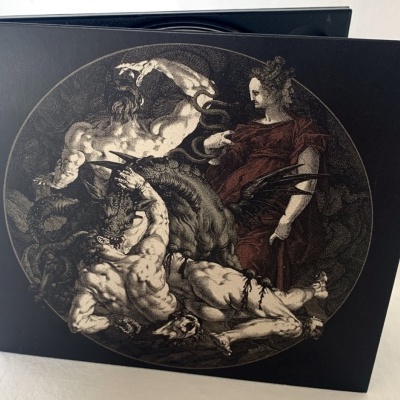 Caixa preta com imagem circular mitológica em tons castanhos e pretos