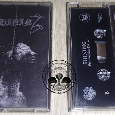 Cassete preta com capa e fita de áudio, texto SHINING e imagens fantasmagóricas