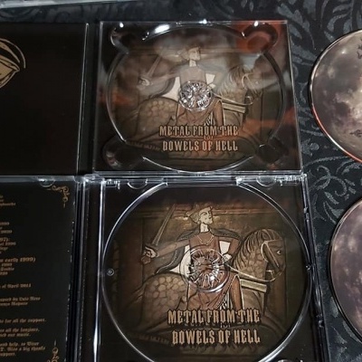 Quatro CDs com capas e encartes, com textos e arte em tons de bege, preto e dourado.