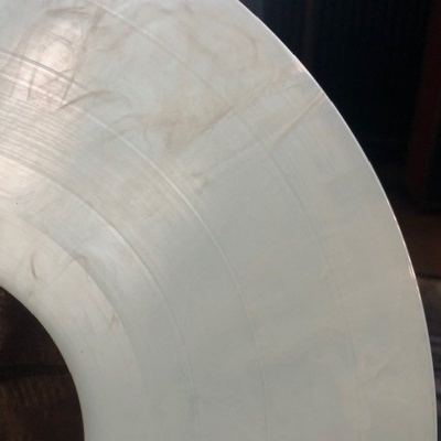 Disco de vinil branco com riscos e marcas de uso