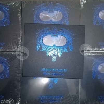 Sete caixas quadradas pretas com decoração azul metálica e texto azul empilhadas.