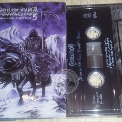 Cassete musical Obsecration Storm of the Lights Bane com capa gótica roxa e texto