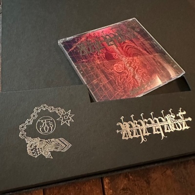 Caixa preta com CD e dois logótipos prateados na superfície