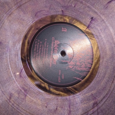 Vinil translúcido púrpura e dourado com selo preto e texto vermelho