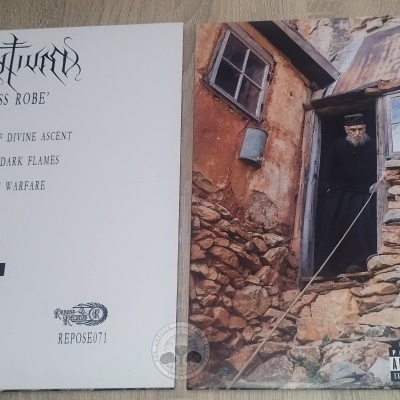 Disco vinil com capa dupla, texto e imagem de homem junto a casa de pedra