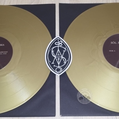 Dois discos de vinil dourados sobre capas pretas com logotipo entre eles