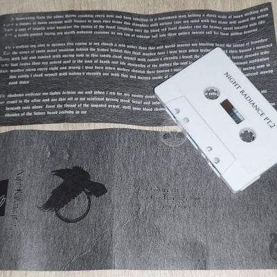 cassete de áudio branca com texto Night Radiance TT2 sobre fundo cinzento com imagem de pássaro e texto