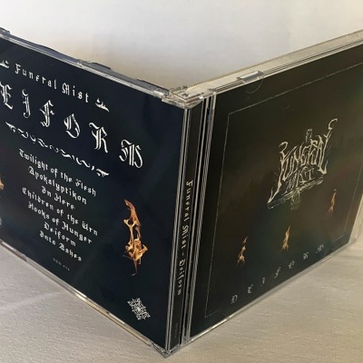 Caixa de CD preto com texto branco e detalhes dourados sobre fundo branco