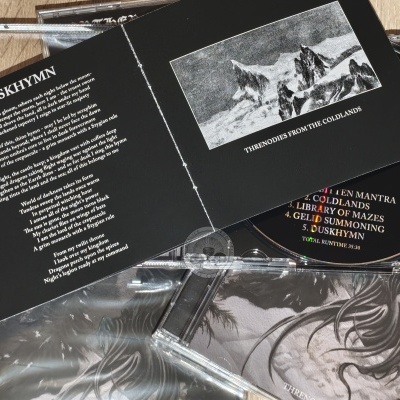 CD com inserto preto com texto de música e imagem de montanhas e lobos em preto e branco