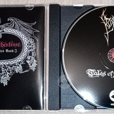 Caixa aberta de CD preto da banda Venom com o título Tales of Wolvering The Odin Chronicle Book 3 em branco e vermelho