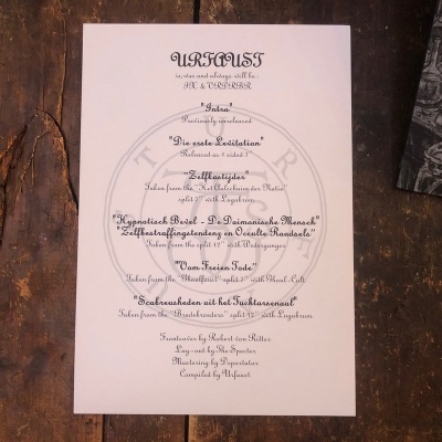 Papel branco com texto em tinta preta sobre superfície de madeira rústica