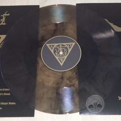 Vinil preto com desgaste dourado, capa preta e dourada com símbolos e texto em espanhol.