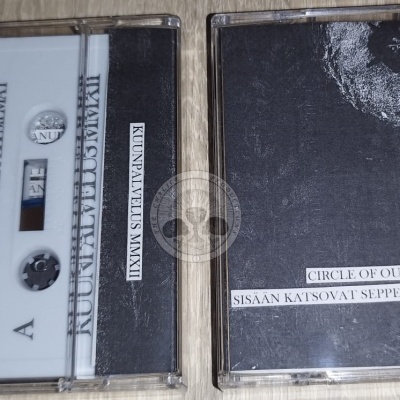 Duas cassetes de áudio e caixas transparentes, uma branca com texto preto e outra preta com texto branco