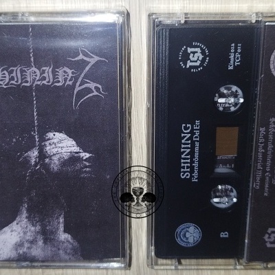 Duas cassetes de áudio SHINING com capa preta e branca e estojo sobre madeira clara