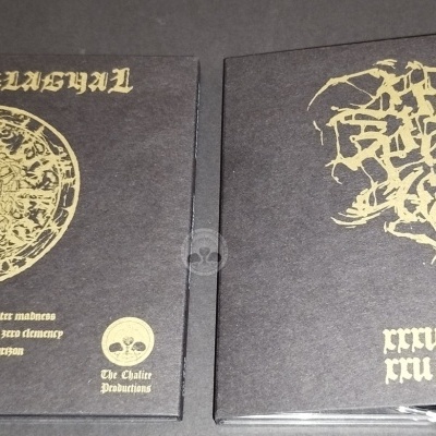 Duas caixas de CDs pretas com estampagem dourada e textos artísticos