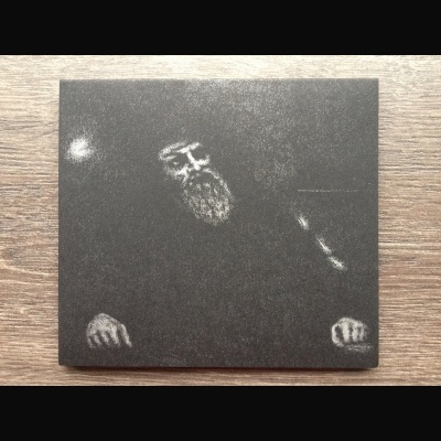 Capa de álbum preto e branco com homem idoso e barba numa superfície de madeira