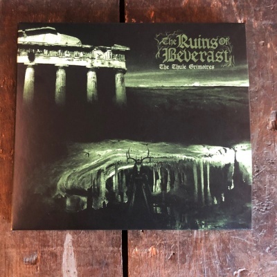 Capa de álbum com ruínas gregas e texto dourado em fundo escuro