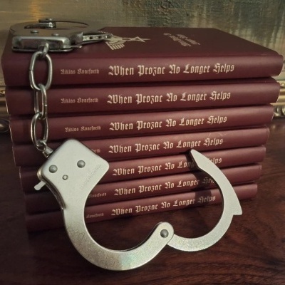 Seis livros vermelhos empilhados com algemas metálicas prateadas em cima de uma mesa de madeira.