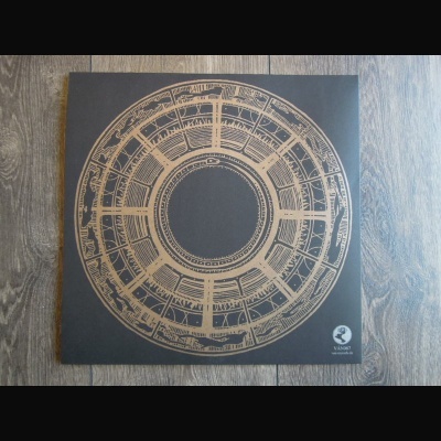 Capa de álbum preta com desenho circular dourado e texto VAND em fundo de madeira