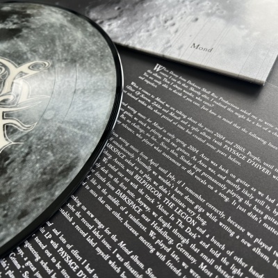 Disco de vinil Pixies sobre capa preta com texto e superfície cinza ao fundo com palavra Mond