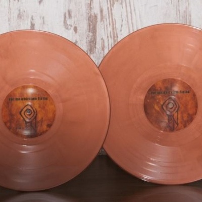 Dois discos de vinil cor de cobre com rótulos centrais que incluem o texto THE SMASHING PUMPKINS