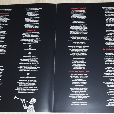 Encartes de folhas pretas com texto branco e vermelho e ilustrações brancas nas extremidades inferior