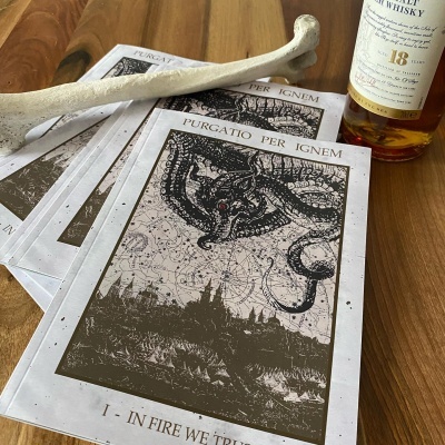 Revistas com capa ilustrada de monstro e texto Purgatio Per Ignem sobre mesa de madeira