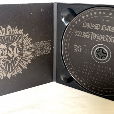 Estojo preto aberto com disco de CD preto e brasão dourado