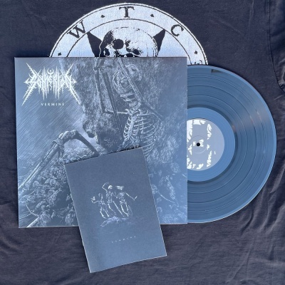 Vinil azul com capa ilustrada e livreto sobre t-shirt preta com logotipo circular W.T.C.