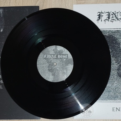 Vinil preto com capas em preto e branco ao fundo: capa preta com lista de faixas, capa branca com estátua e texto