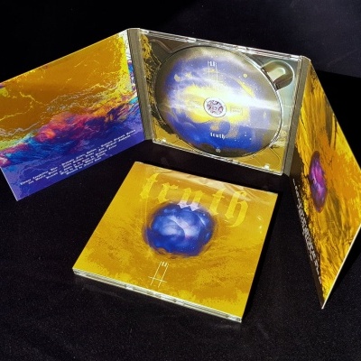Caixa de CD dourada e azul com arte abstrata e a palavra truth