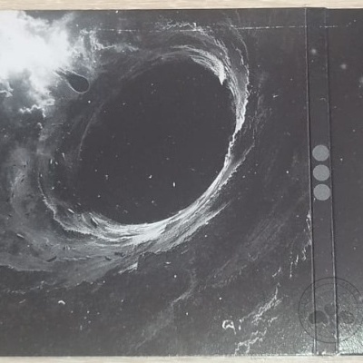 Capa de álbum preto e branco com tema espacial, texto visível e desenhos geométricos.