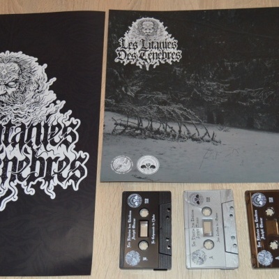 Conjunto Les Litanies Des Ténèbres com pôsteres, cassetes, pins e cartão numerado sobre madeira clara