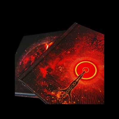 Dois livros com capas duras em tons vermelhos e pretos com ilustração abstrata e círculo amarelo