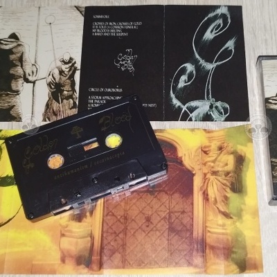 Cassete preto com capas e livreto em papel com imagens e texto em inglês, sobre superfície clara