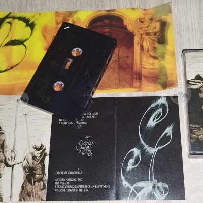 Cassete preto com capas impressas em papel sobre superfície cinzenta