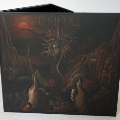Caixa com design gráfico de criatura medusa e texto 'LUCIFER', 'Broken Seal'
