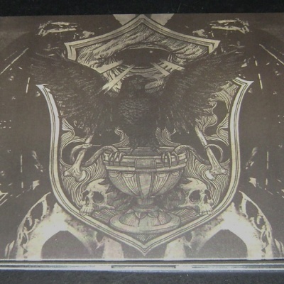 Caixa quadrada com brasão detalhado em tons de cinza, preto e bege.