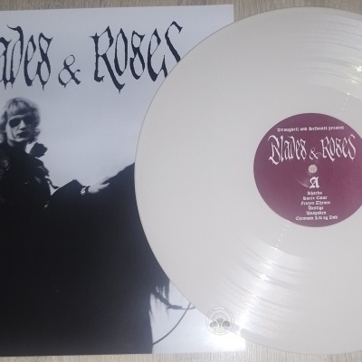 Vinil branco com etiqueta roxa e capa de álbum Blades & Roses ao lado